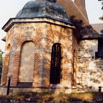 Restaurerad kyrkobyggnad med tegel och natursten