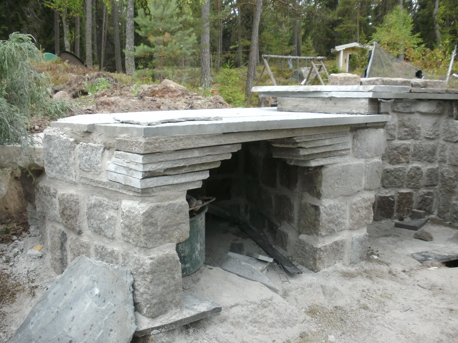 Utekök under uppbyggnad med natursten och bänkskiva
